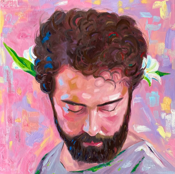Portrait of a bearded father with flowers behind his ears, against a pink background.